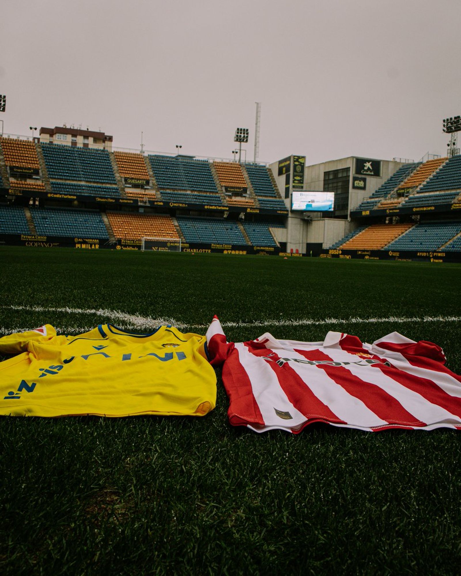 Imagen de las camisetas del Cádiz y el Sporting, sobre el césped del Nuevo Mirandilla.