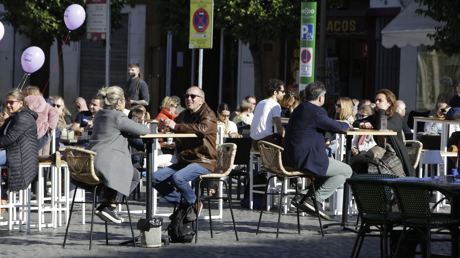 Ciudadanos tomando el fresco en un velador de Sevilla.