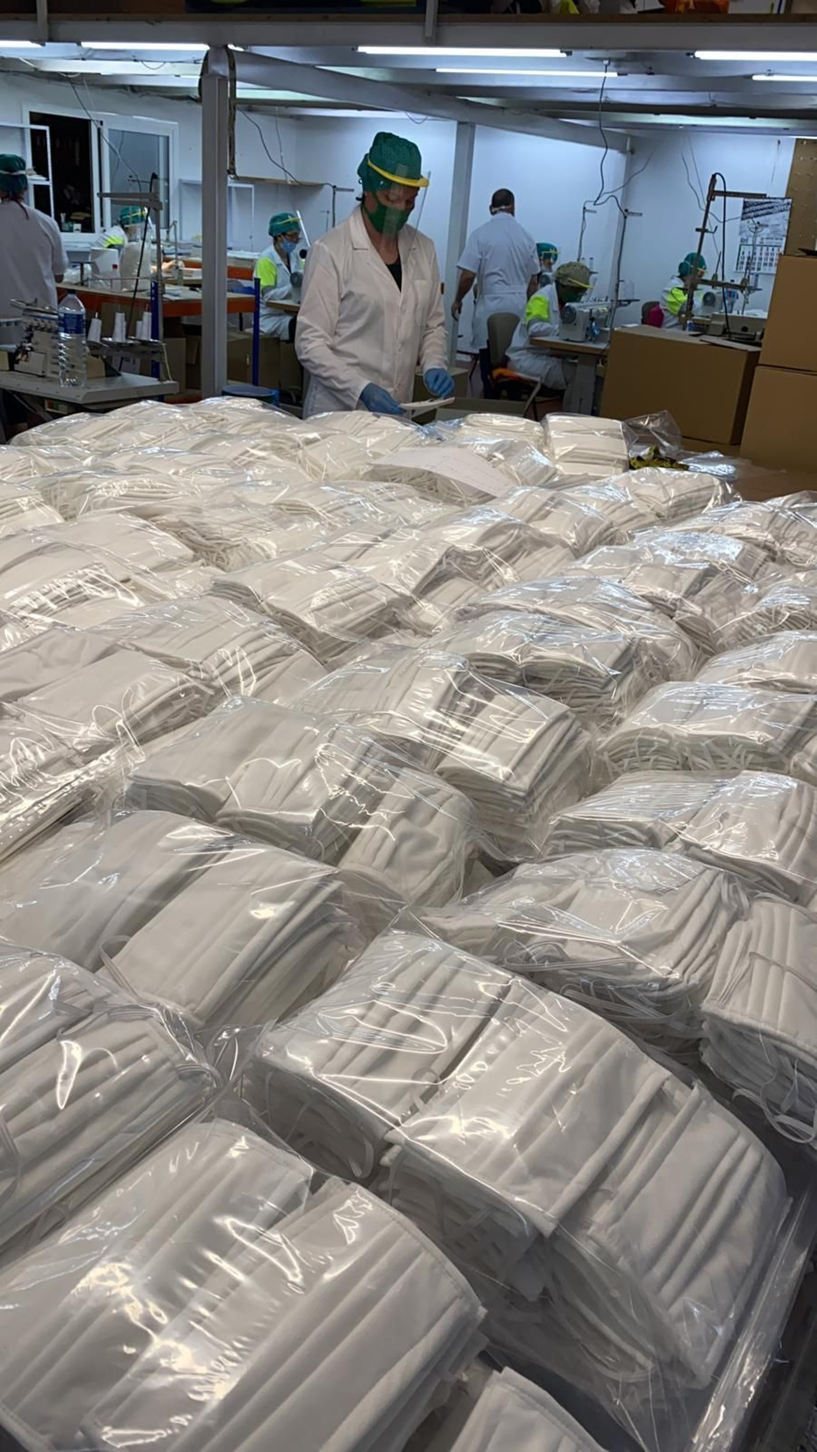 Operarios trabajando en la producción de mascarillas quirúrgicas del tipo IIR.