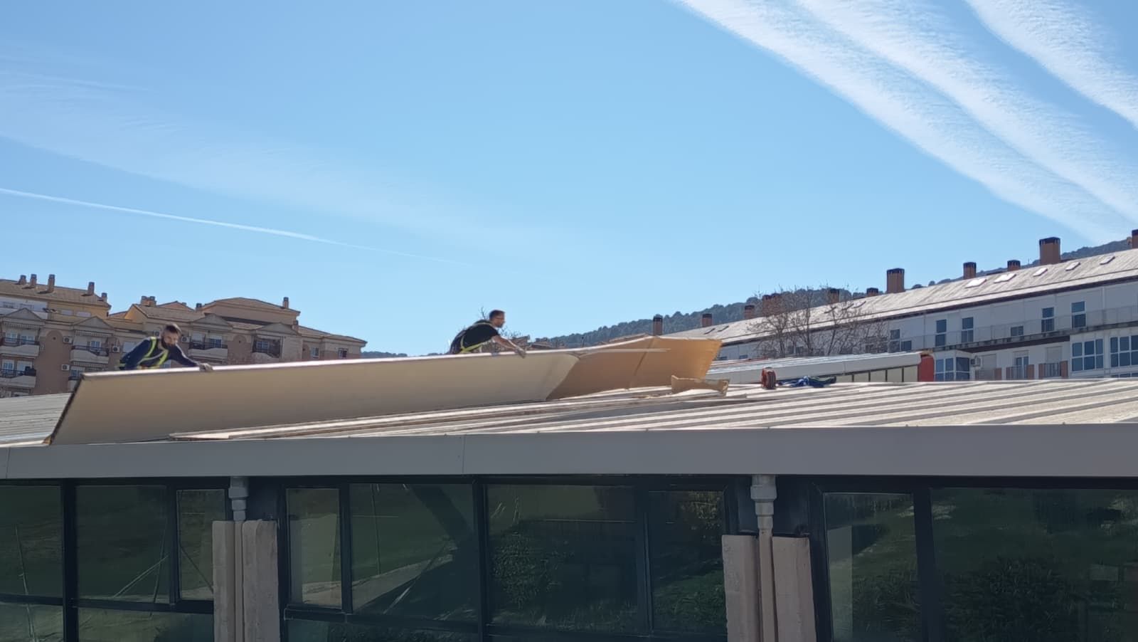 Operarios municipales en la cubierta de la piscina de Las Fuentezuelas.