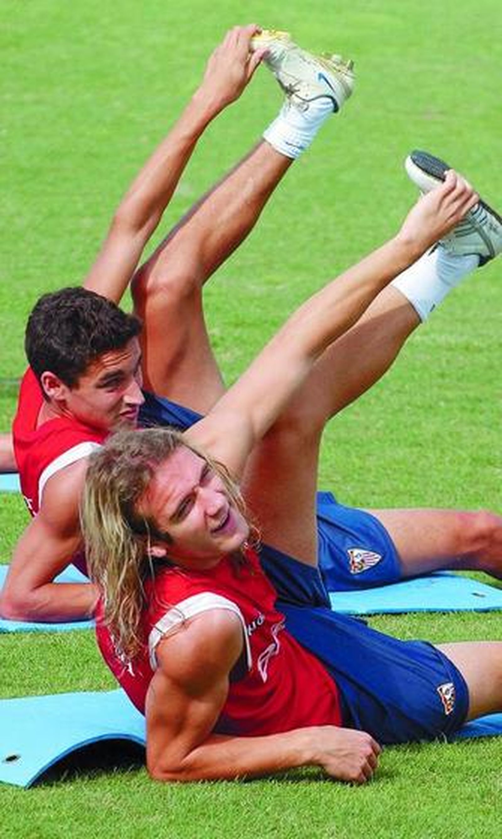Diego Capel y Jesús Navas hacen ejercicios de estiramiento durante la sesión de ayer.
