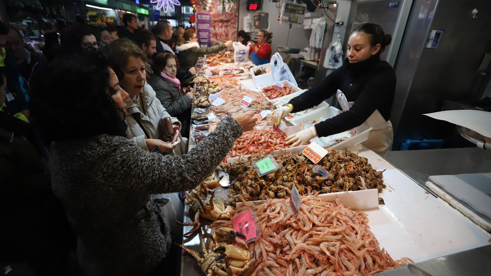 Una mujer compra marisco en uno de los puestos del Mercado del Carmen.