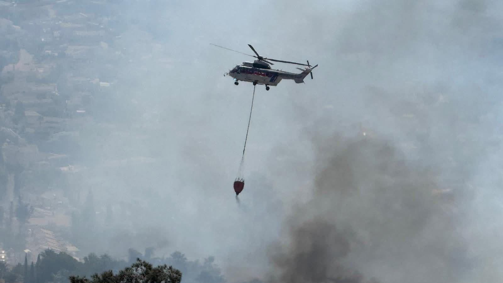 un helicoptero apagando el incendio forestal de Benalmádena