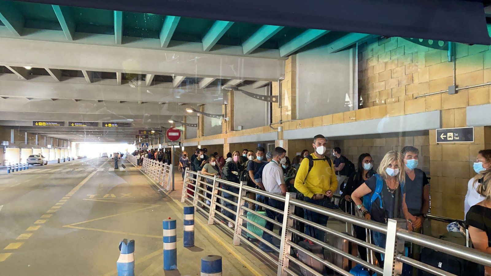 Colas de pasajeros en la parada de autobús del aeropuerto de Sevilla.