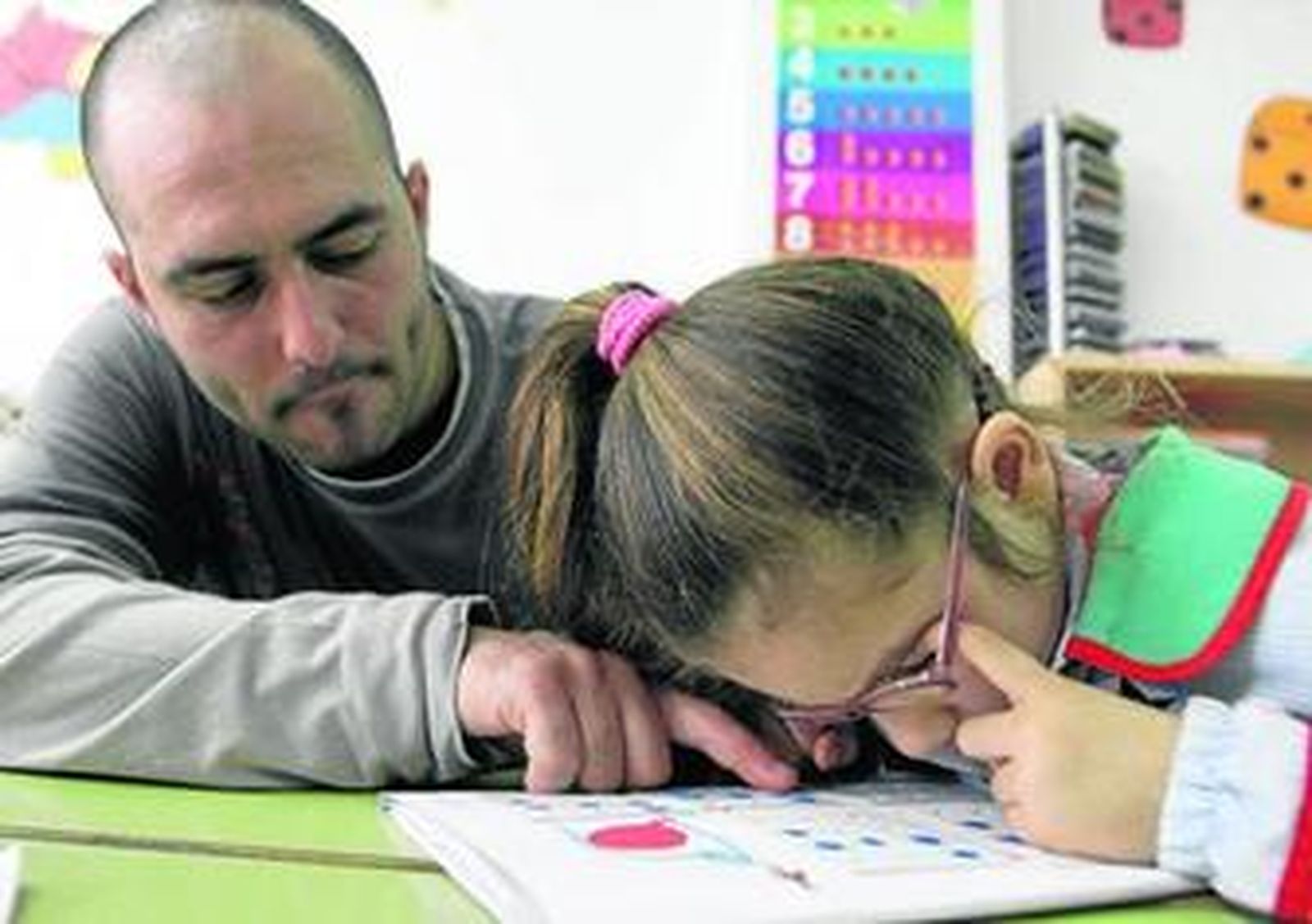 El maestro en prácticas Francisco Pelayo ayuda a Carolina Carrera Heredia a hacer las fichas en clase, ayer, en el colegio Padre Manjón.