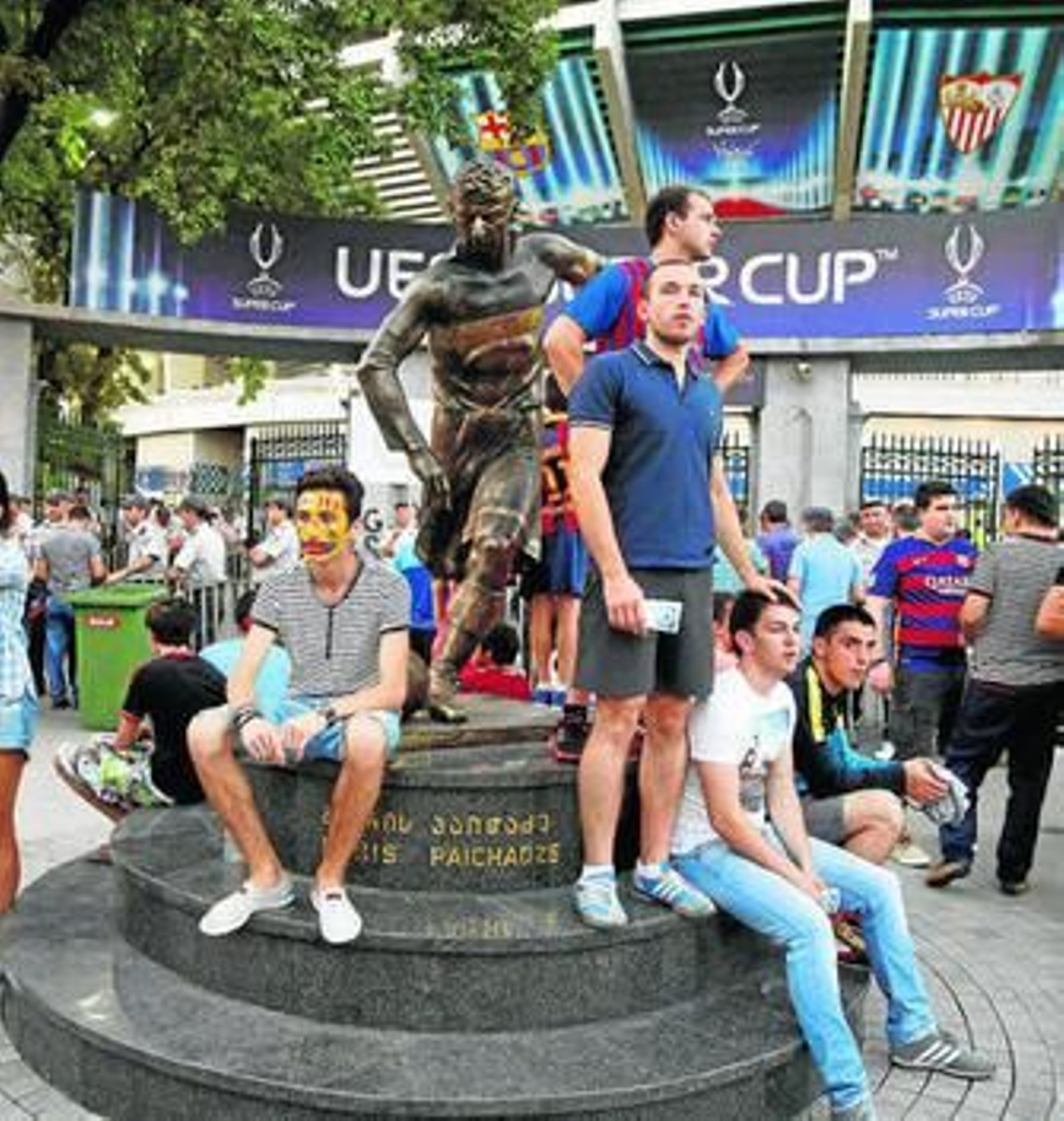 Varios hinchas ante la estatua del futbolista geogiano Boris Paichadze, que da nombre al estadio.
