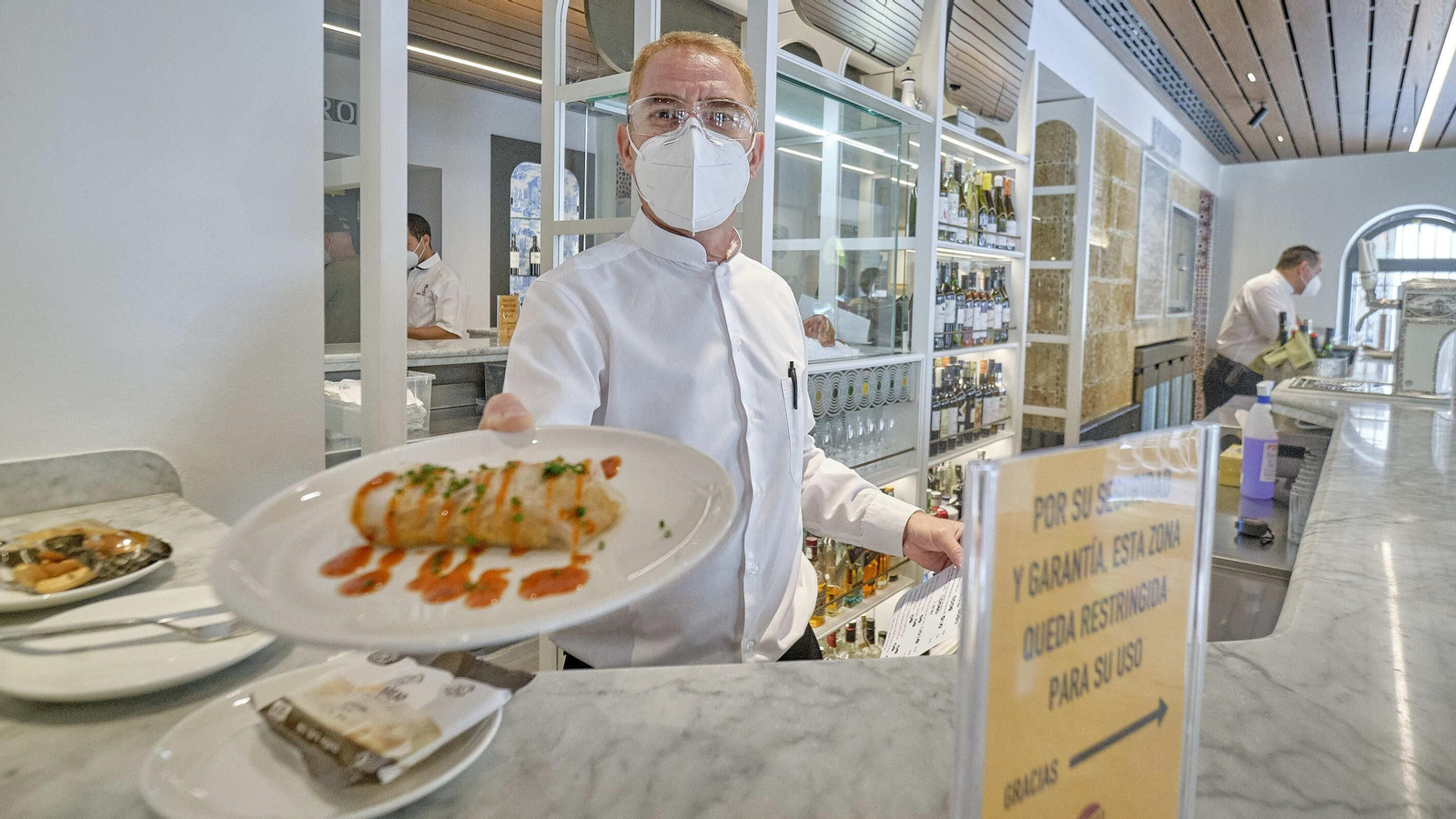 David, el jefe de barra, sirviendo un Canelón de arroz y mariscos