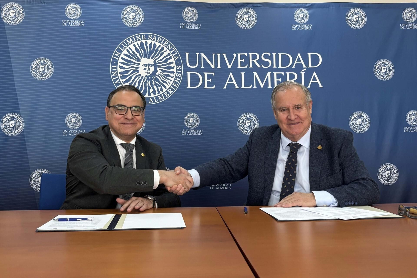 El rector, José J. Céspedes, y el presidente del Colegio de Médicos, Francisco J. Martínez Amo, se saludan tras la firma del protocolo de actuación.