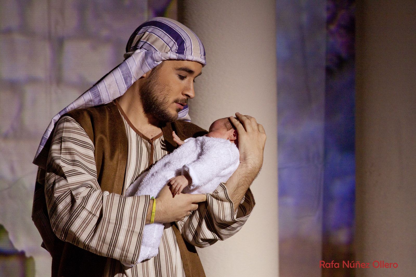 San José sostiene al Niño Jesús en el belén viviente de los Padres Blancos.