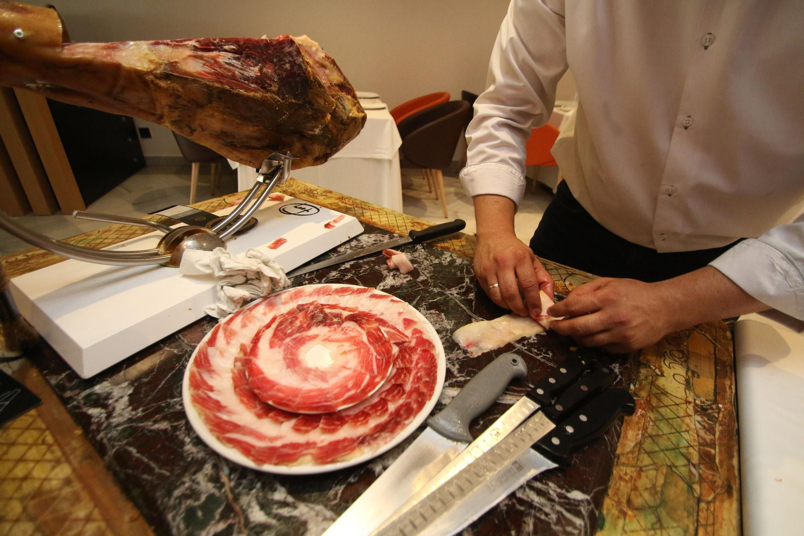 Un cortador de jamón emplatando una ración.