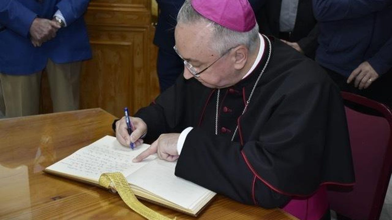 El obispo, firmando en el libro de honor de la hermandad para tan especial ocasión.