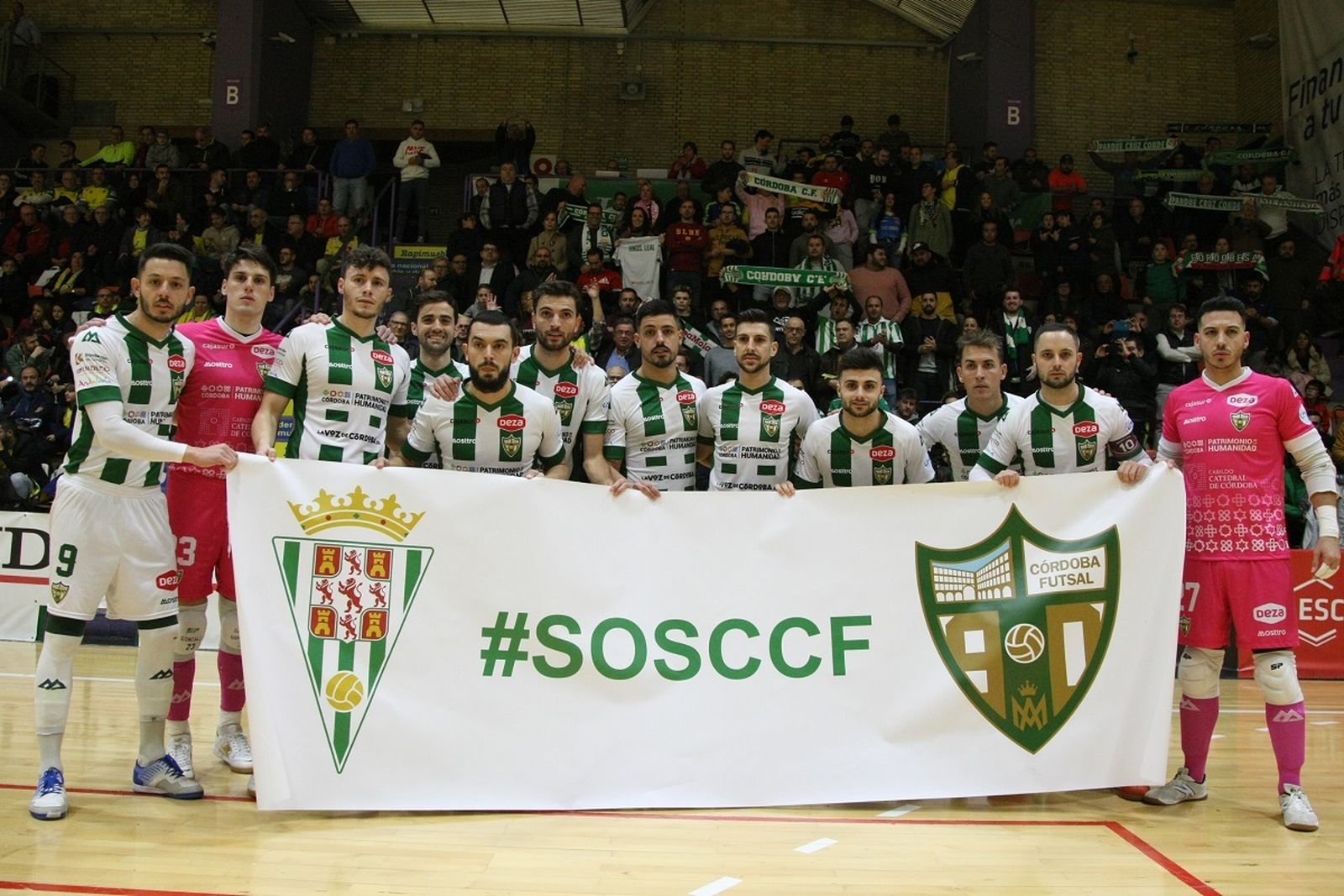 Los jugadores del Córdoba Patrimonio de la Humanidad posan con una pancarta de apoyo al Córdoba CF.