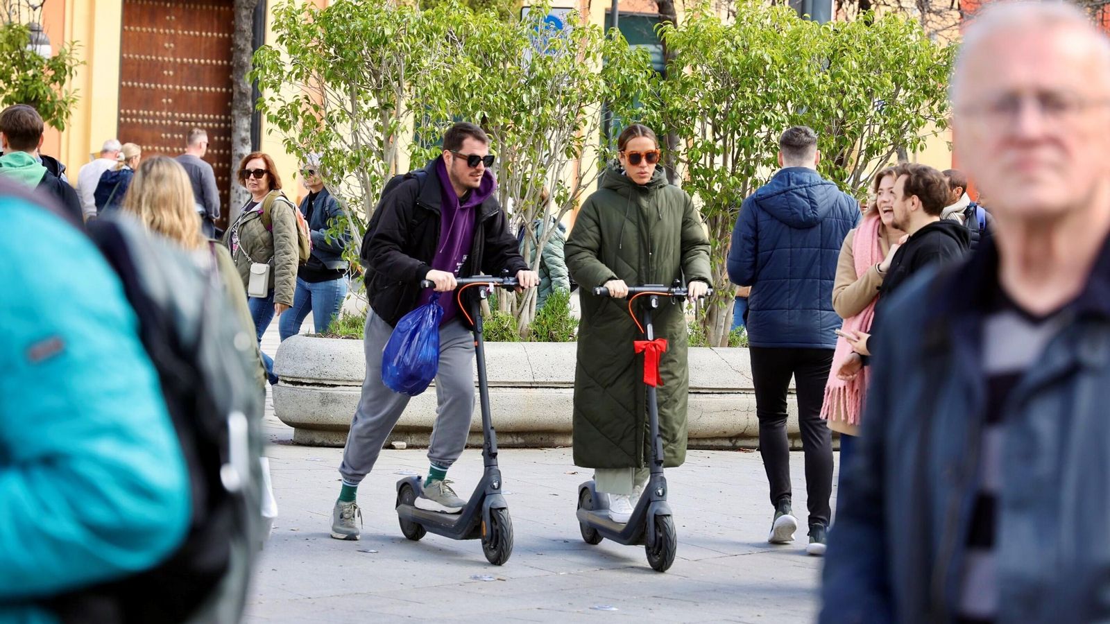 Dos patinetes avanzan en la Puerta de Jerez peatonal.