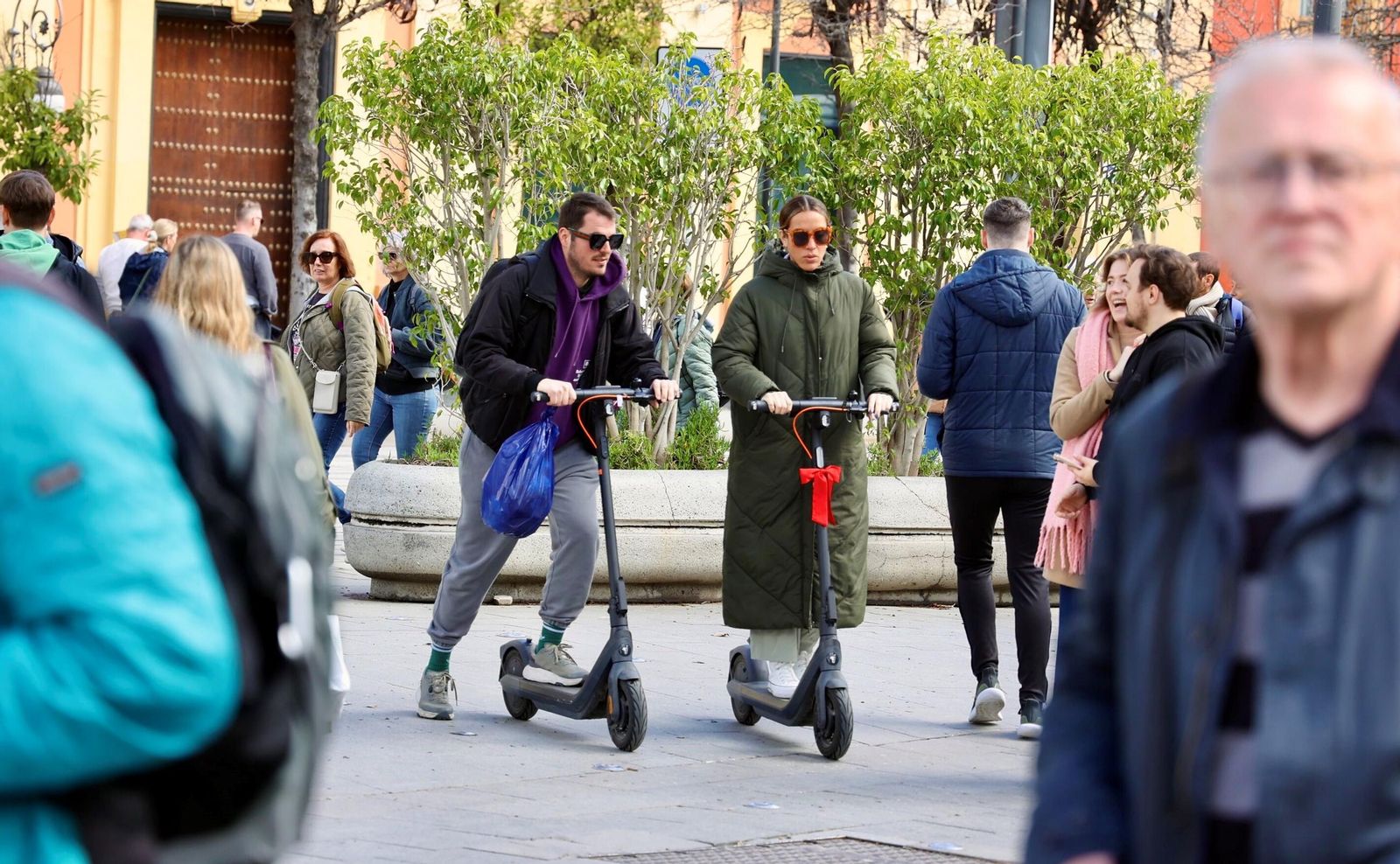 Dos patinetes avanzan en la Puerta de Jerez peatonal.