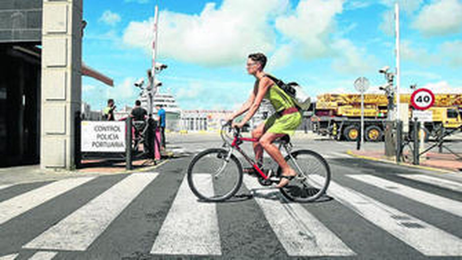 Un ciclista pasa por el paso de peatones que está frente al acceso al Puerto de Cádiz.