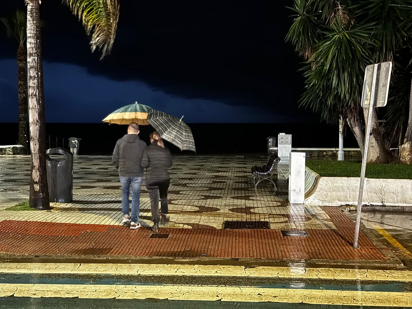 Dos personas pasean por Almuñécar un día de lluvia