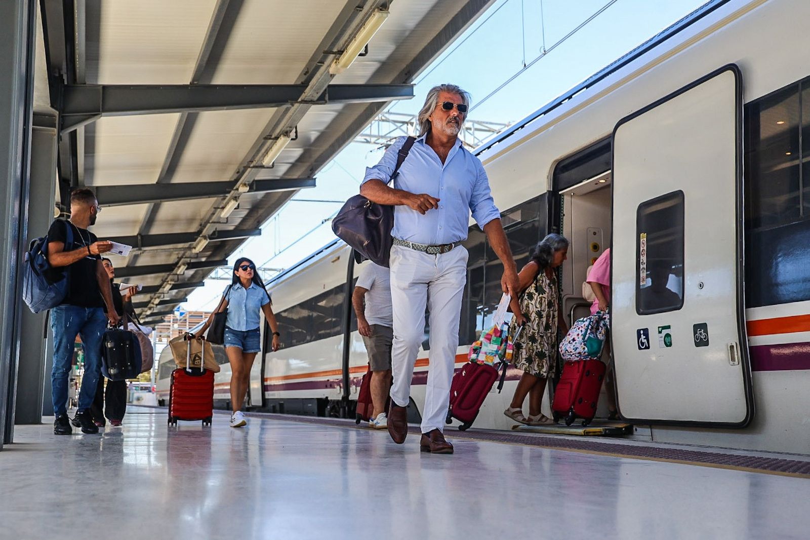Varios pasajeros bajan de un tren en la estación ferroviaria de Huelva.