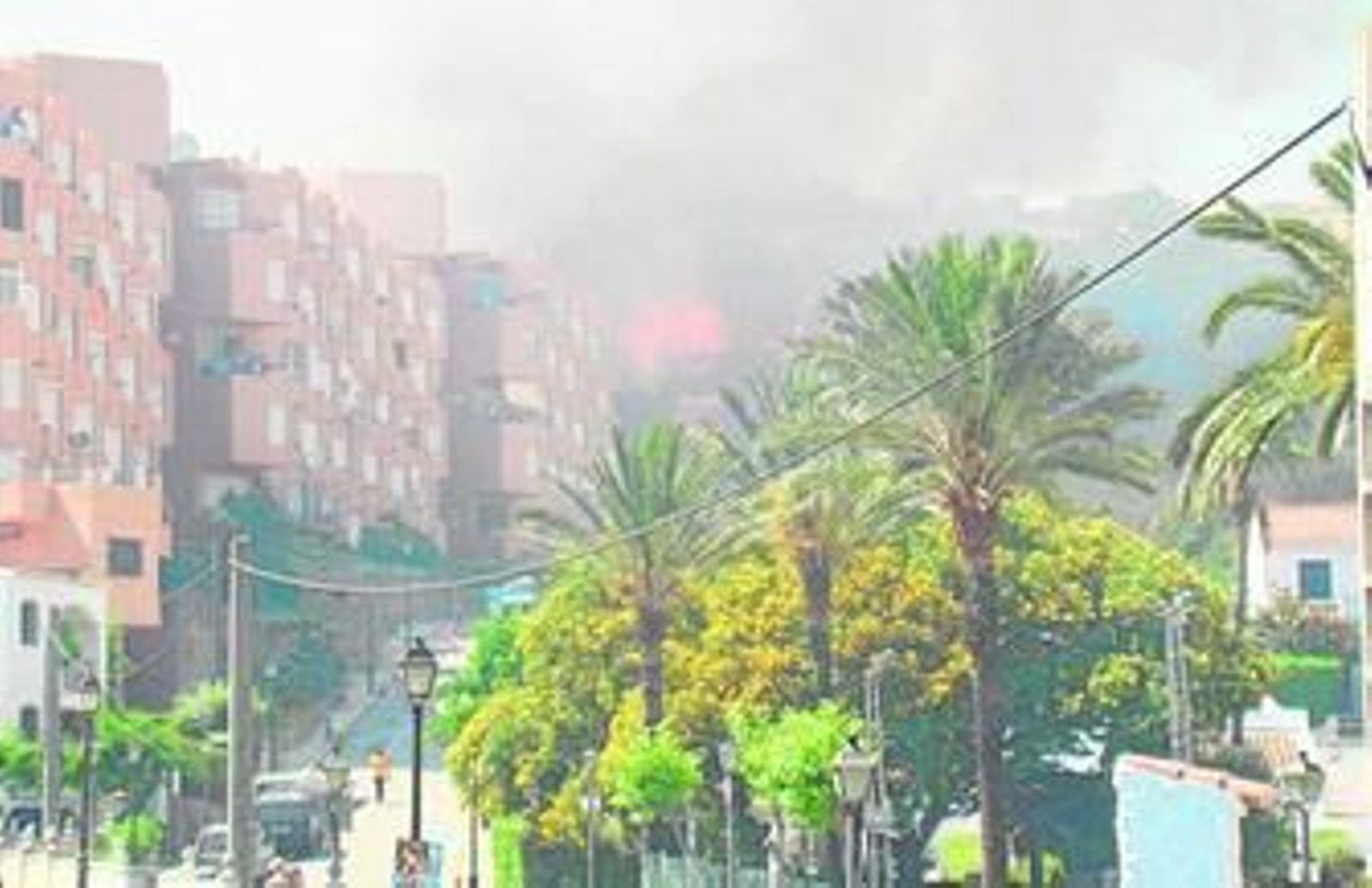 El humo y el fuego en el núcleo de Torreguadiaro, ayer al mediodía.