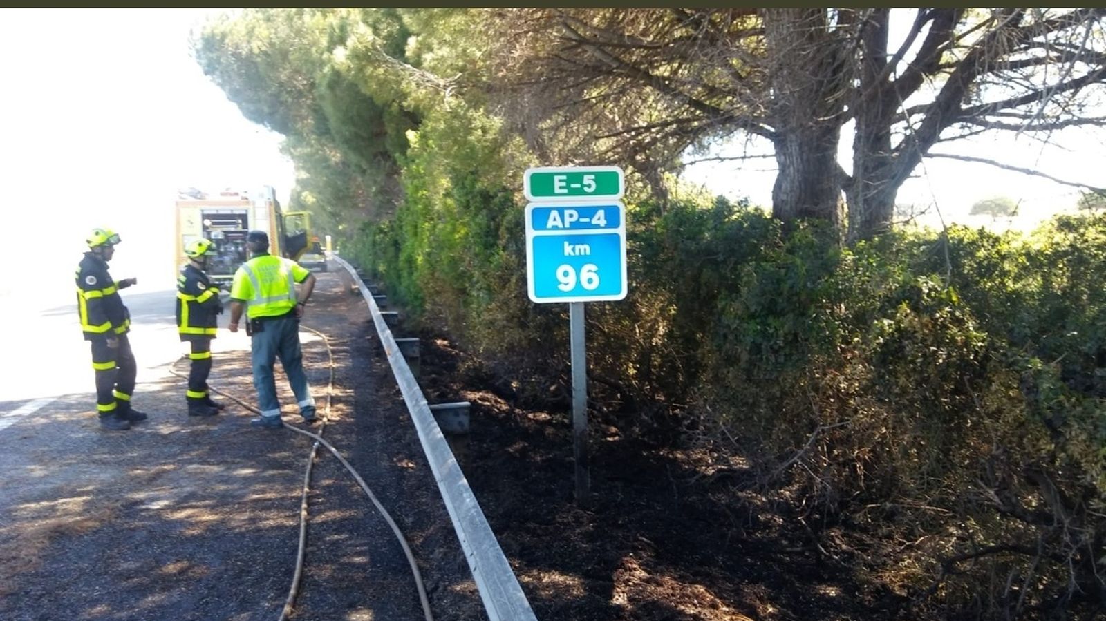 Efectivos de los bomberos junto a la autopista AP-4.