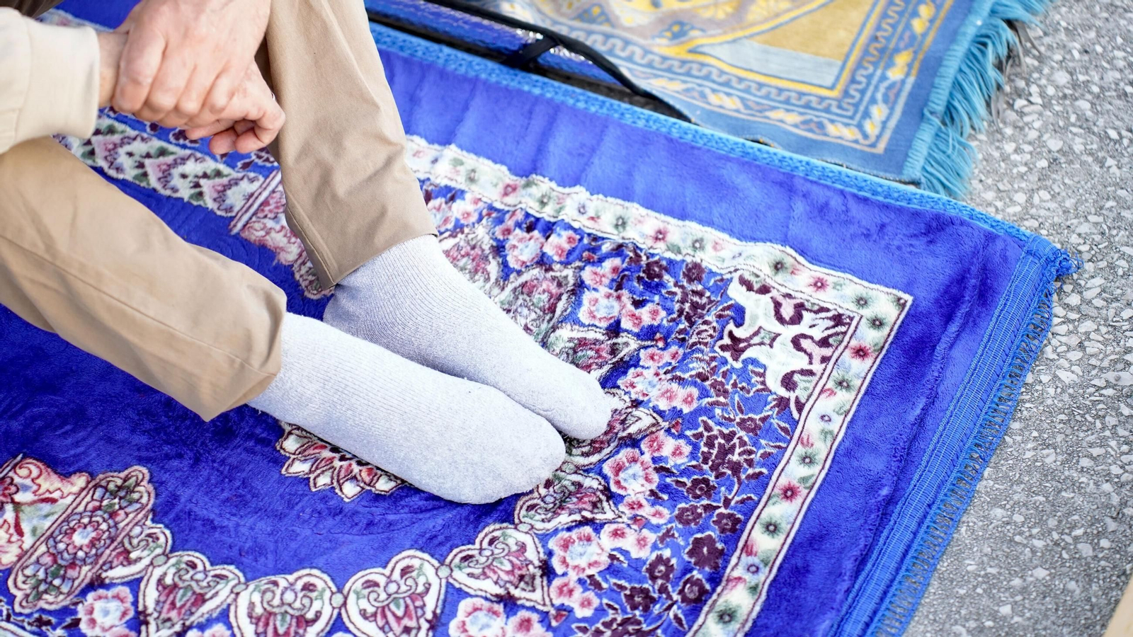 Una persona practicante del islam se dispone a rezar.