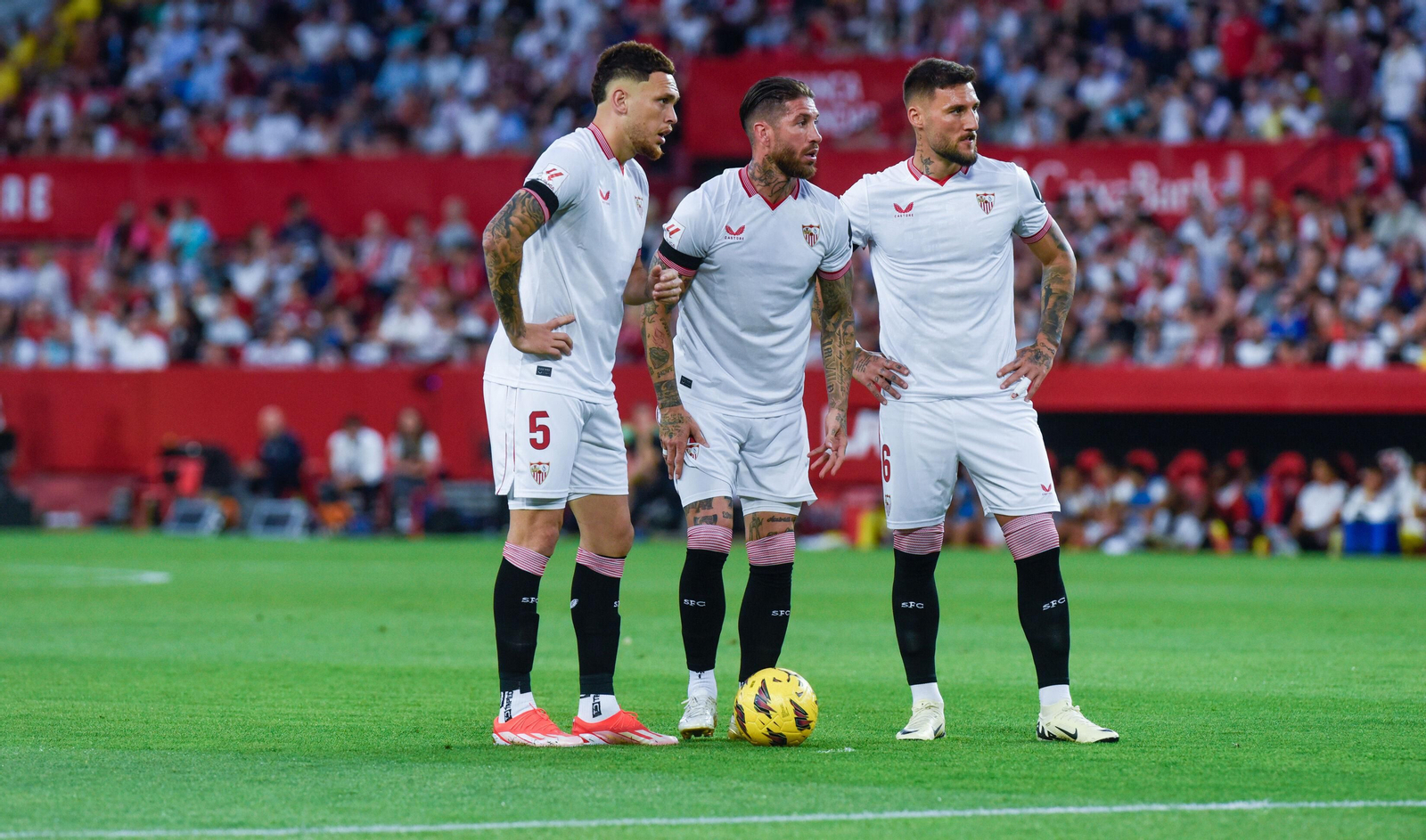 Ocampos, Sergio Ramos y Gudelj, antes de la lesión de éste, en el saque de una falta.