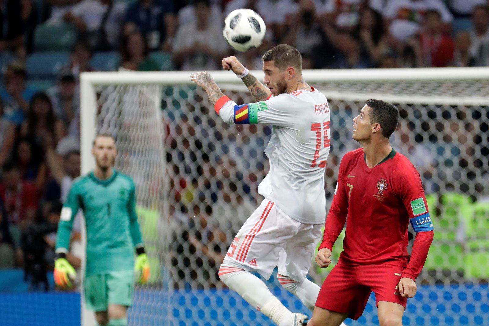 Sergio Ramos le gana un balón aéreo a Cristiano Ronaldo ante la mirada lejana de De Gea