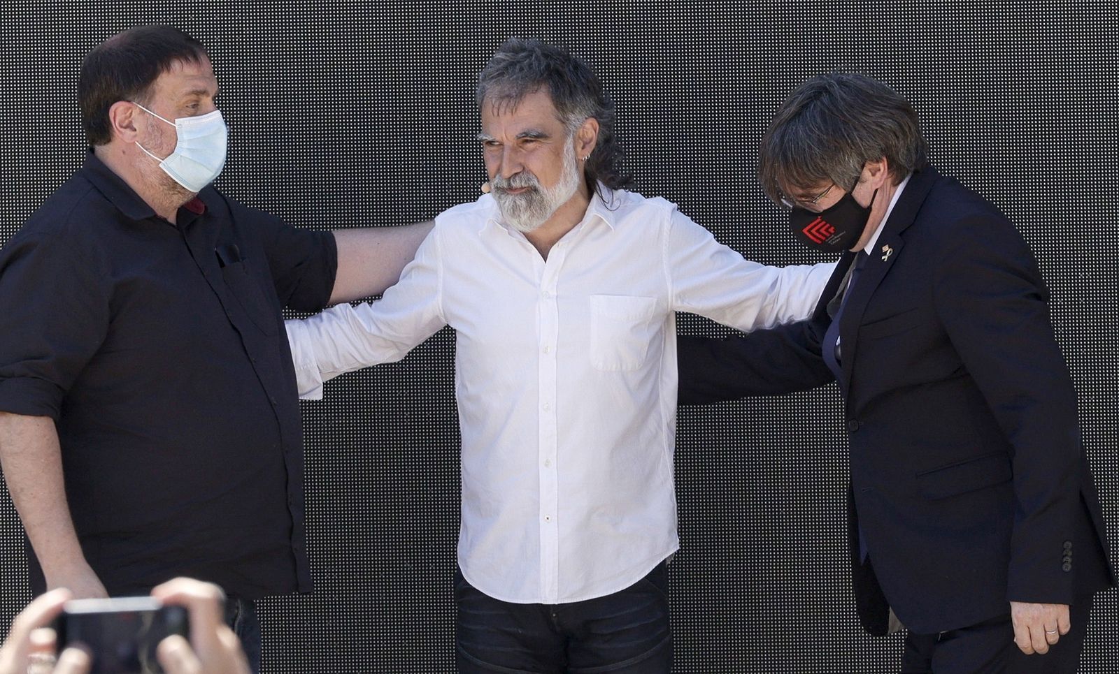 Jordi Cuixart, presidente de Òmnium Cultural, flanqueado ayer en Elna (Francia) por el líder de ERC, Oriol Junqueras (i), y el de JxCat, Carles Puigdemont.