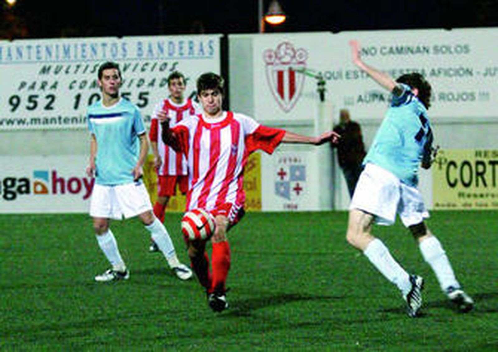 Pablo, jugador del Atlétivo Juval se dispone a golpear el balón ante la llegada de un jugador del Iliturgi.