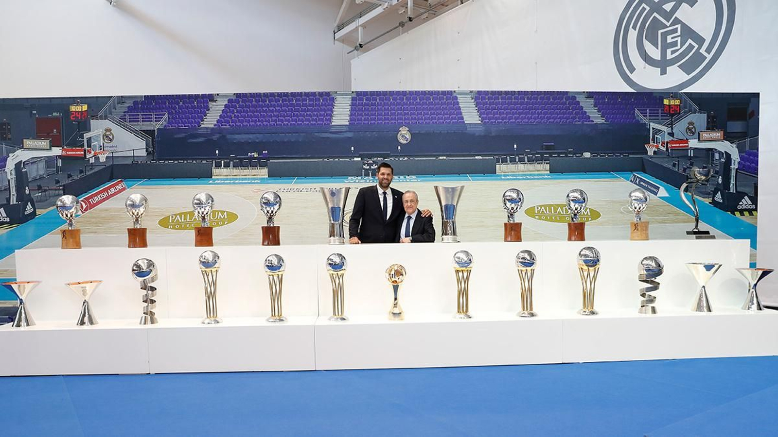Felipe Reyes posa junto a Florentino Pérez y los trofeos que ganó con el Real Madrid.
