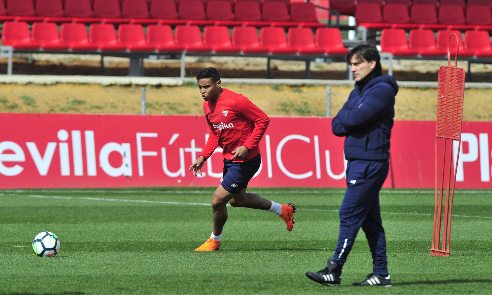 Muriel inicia una arrancada con el balón despegado mientras Montella atiende a otro ejercicio del entrenamiento de ayer.