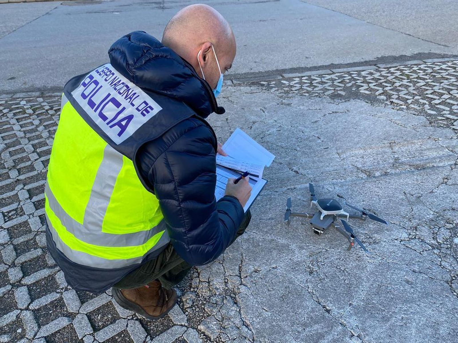 Un policía nacional inspecciona un dron.