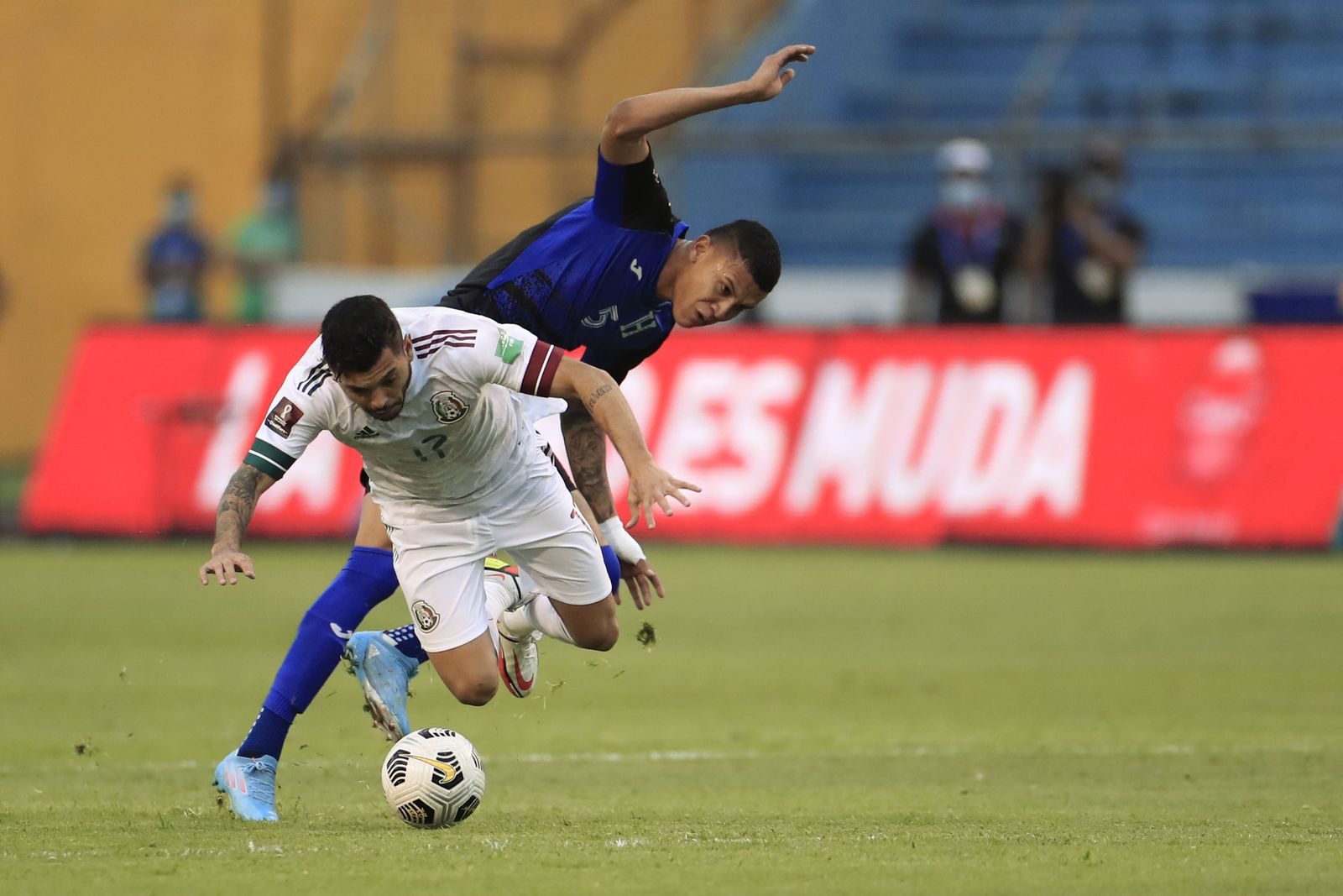 Tecatito Corona cae tras una entrada de un jugador de Honduras.