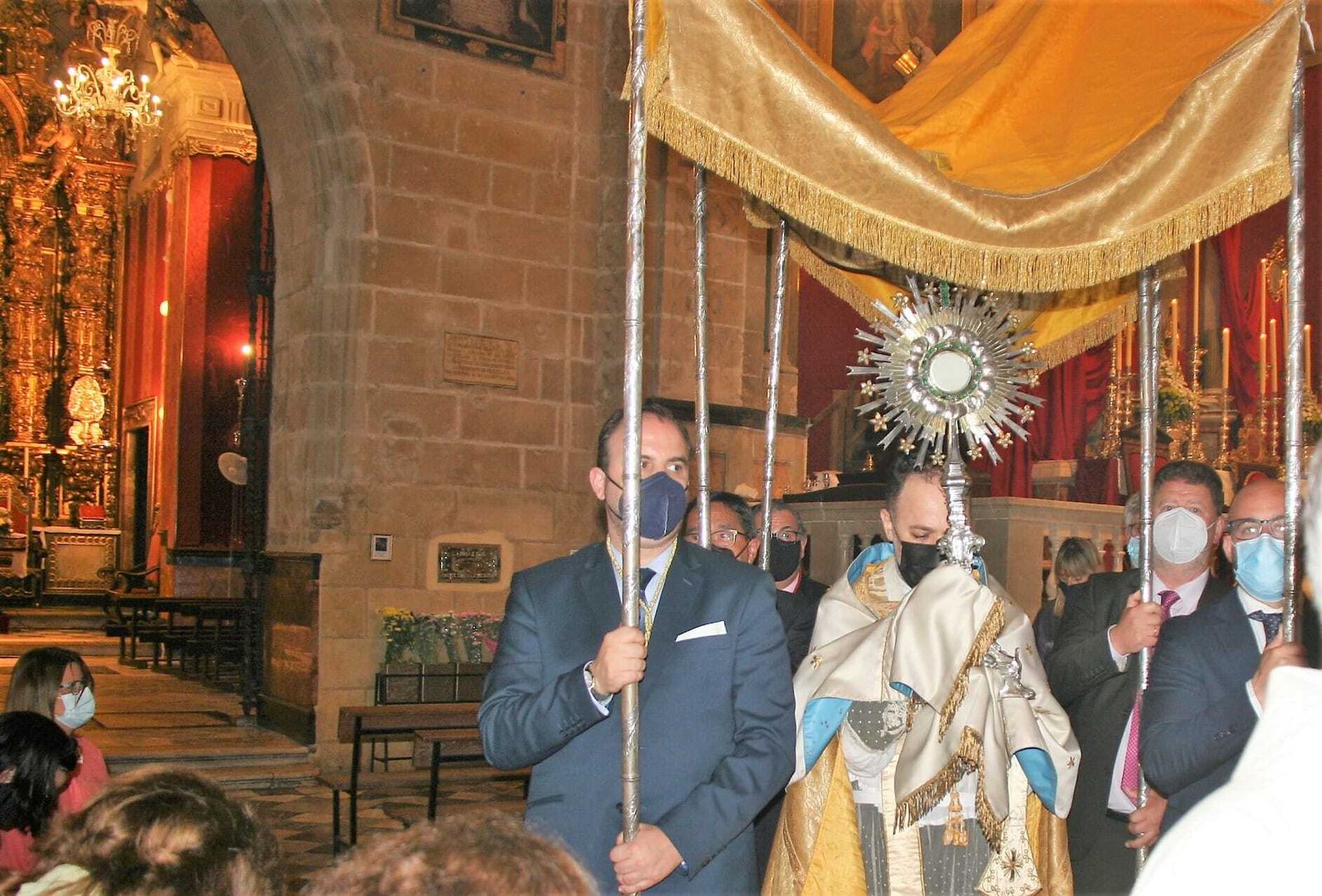 La custodia, portada por el párroco de La Prioral, pasando frente a la capilla de la Virgen de los Milagros.