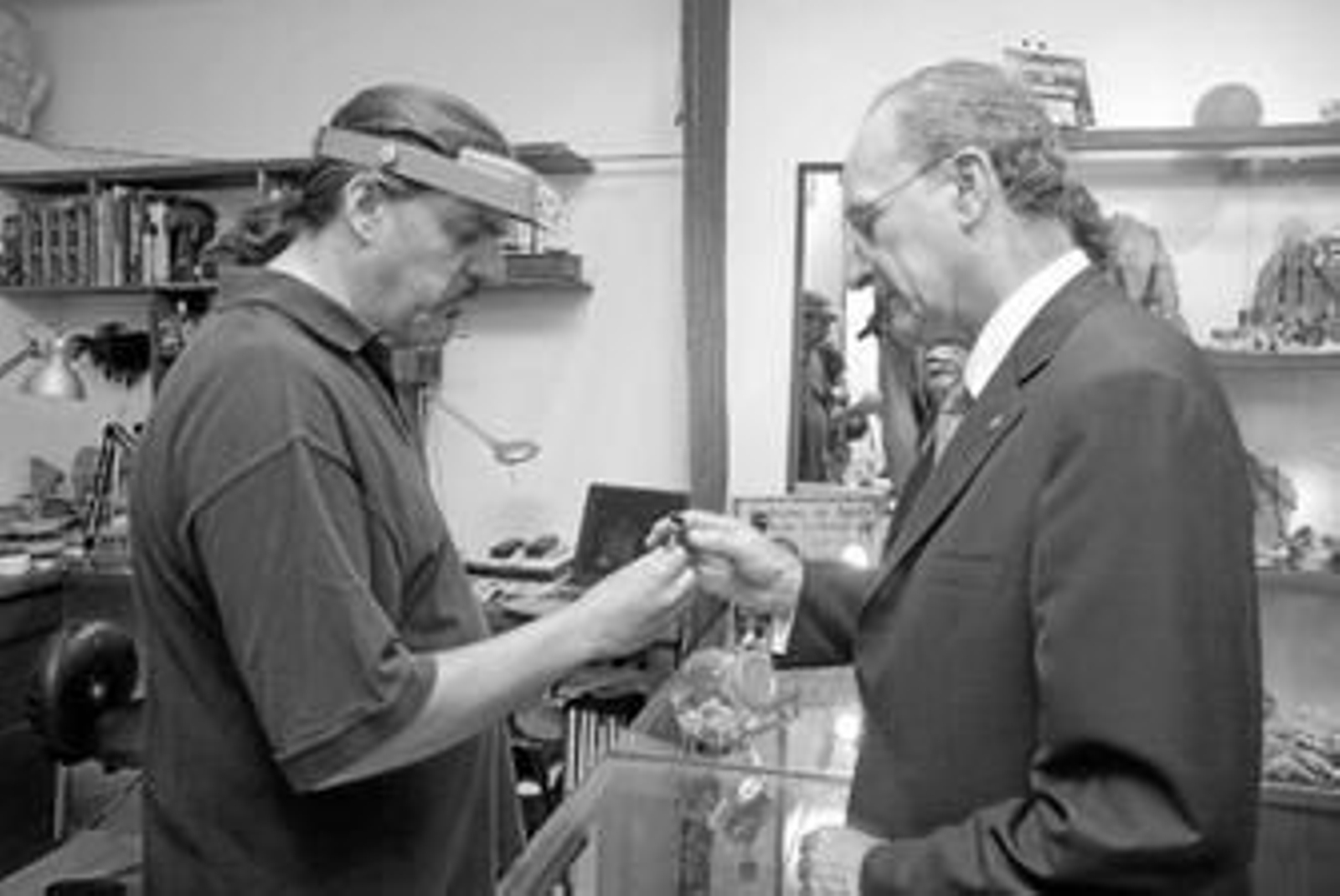 El propietario de una tienda de piedras naturales le muestra una al alcalde, Francisco de la Torre.