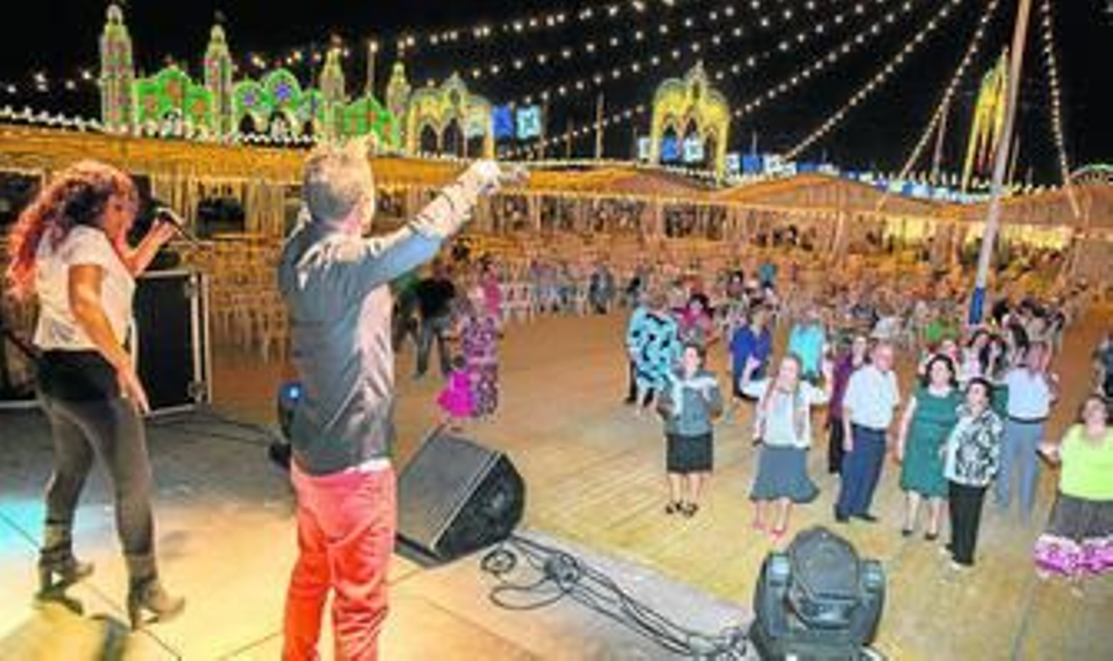 Familias y ancianos disfrutan bailando y cantando al ritmo de la banda del concierto al comienzo de la noche.