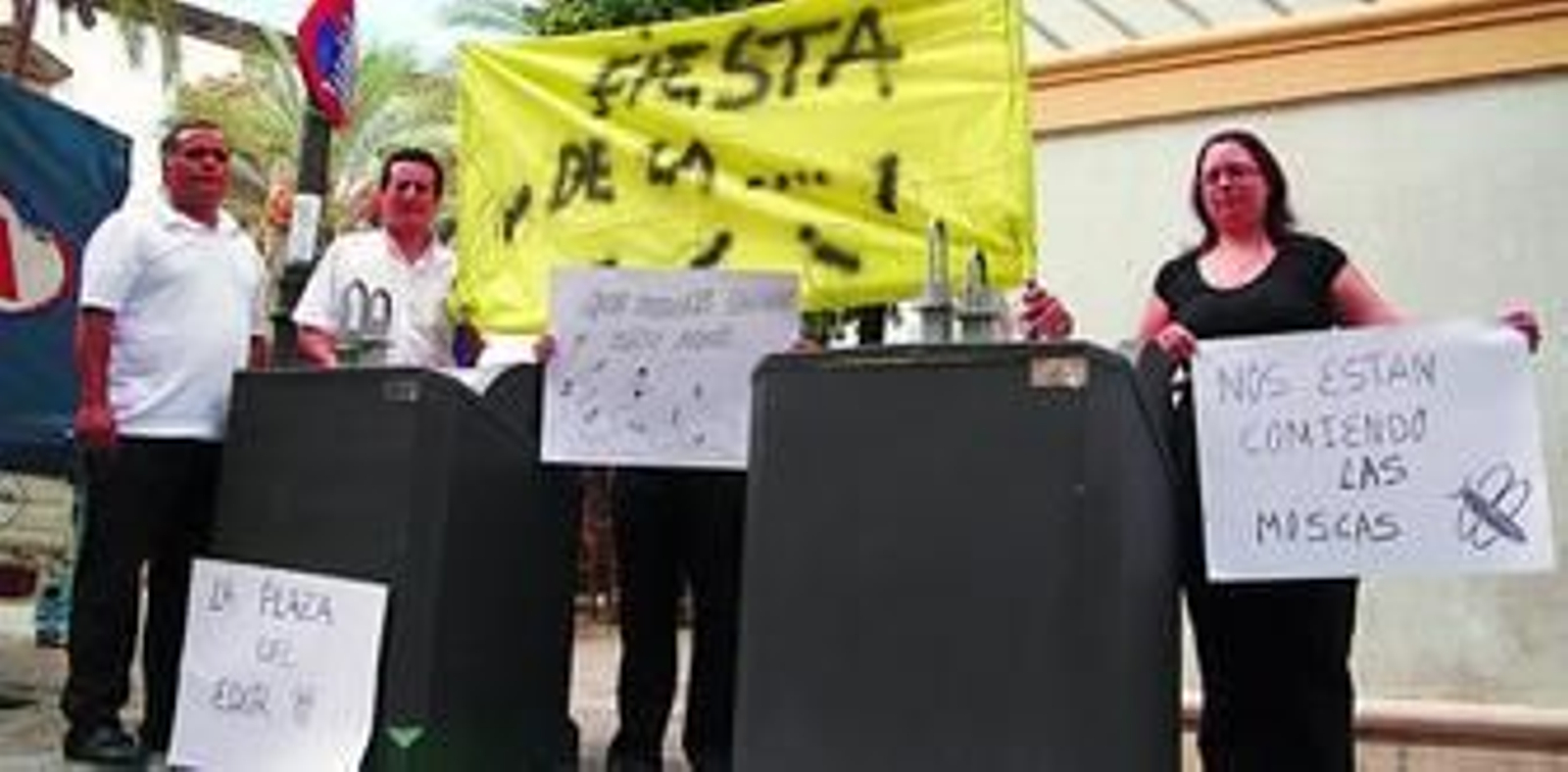 Trabajadores de los bares afectados, ayer con la pancarta de protesta junto a los contenedores.