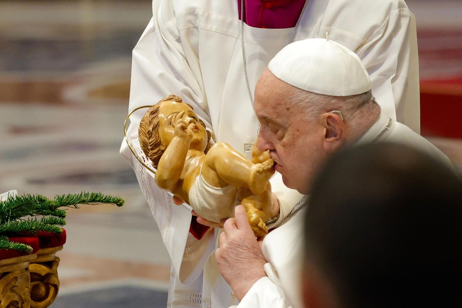 El papa Francisco besa los pies de una figura del Niño Jesús en la Misa de Año Nuevo.