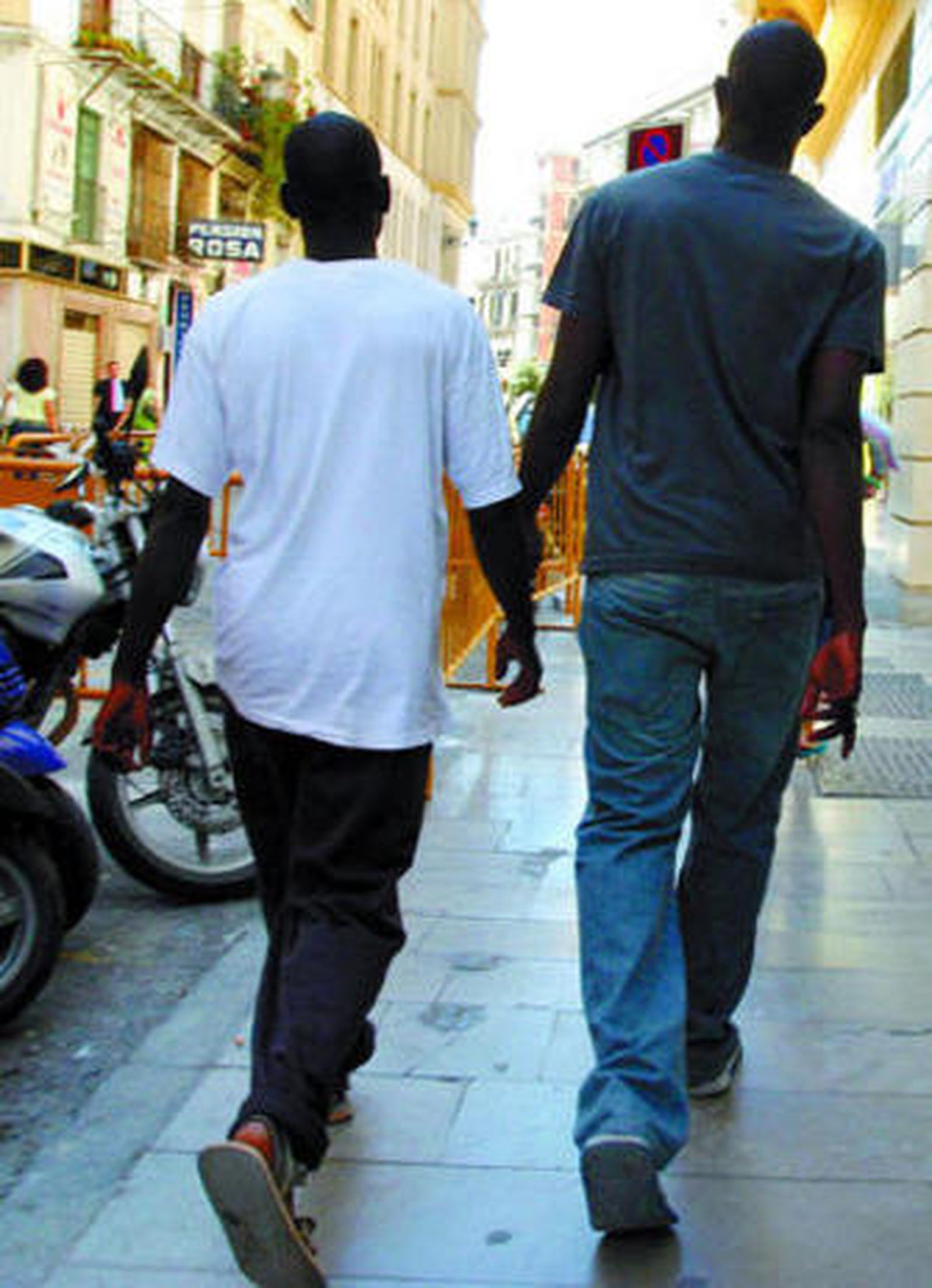 Dos inmigrantes pasean por una calle de la capital.