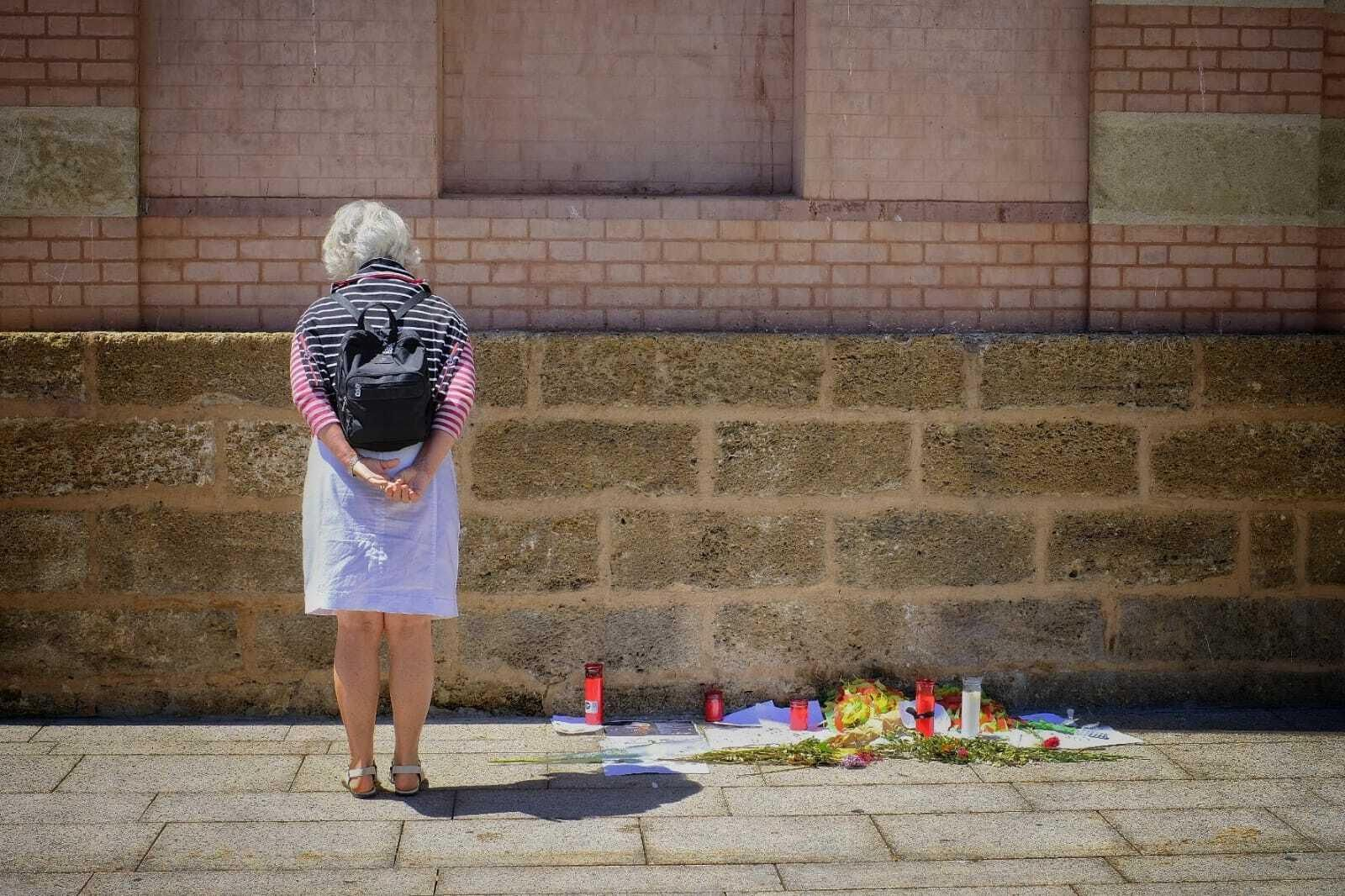 Una turista contempla los mensajes para Juan Carlos Aragón junto a la puerta del Falla.