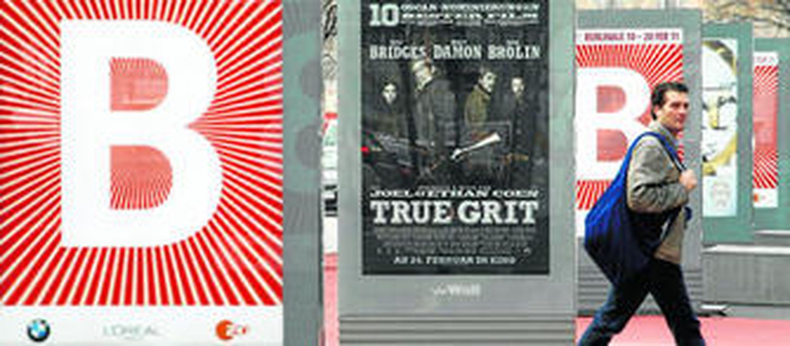 Un hombre pasea junto a un cartel de 'Valor de ley', la película de los Coen que cuenta con 10 candidaturas al Oscar y que abre hoy la programación del festival berlinés.