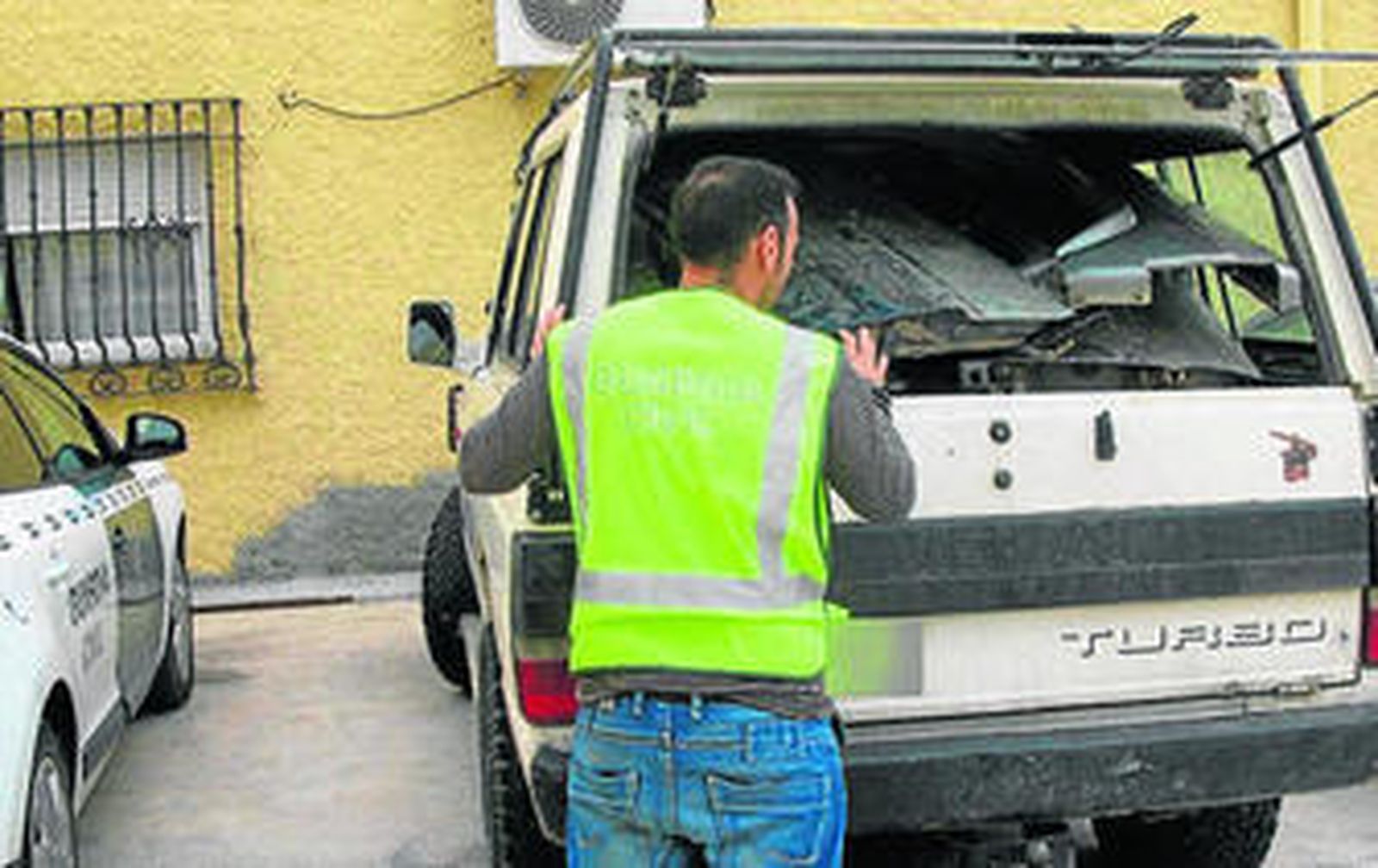 Un agente junto al coche que localizó cargado de piezas de vehículos robados.