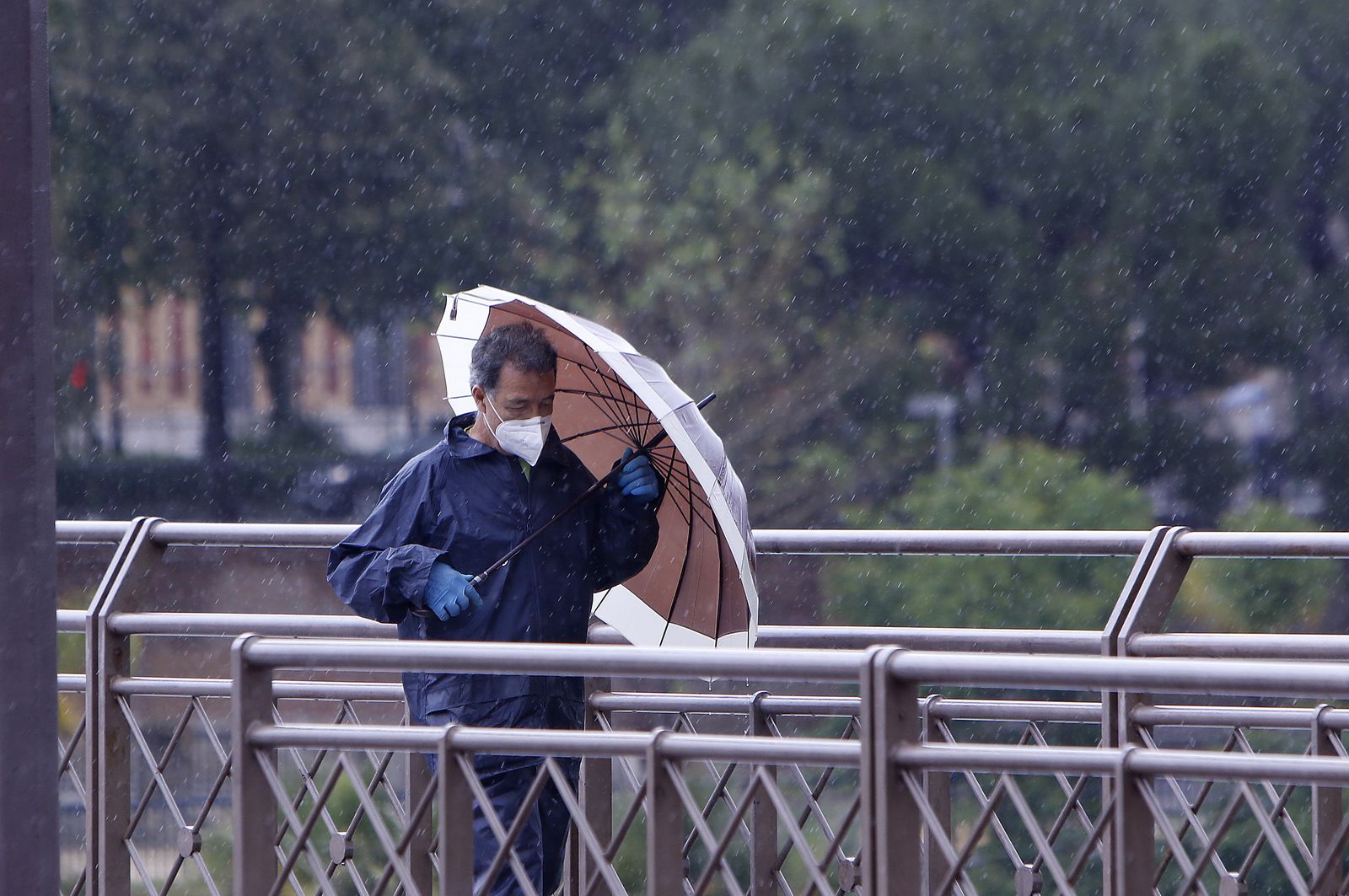 Un hombre se protege de la lluvia con un paraguas.