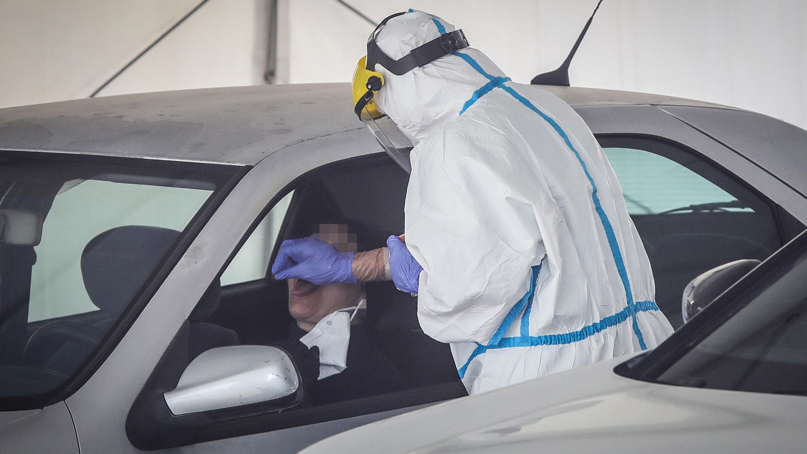 Un sanitario realiza la prueba de PCR a un ciudadano en el autocovid.