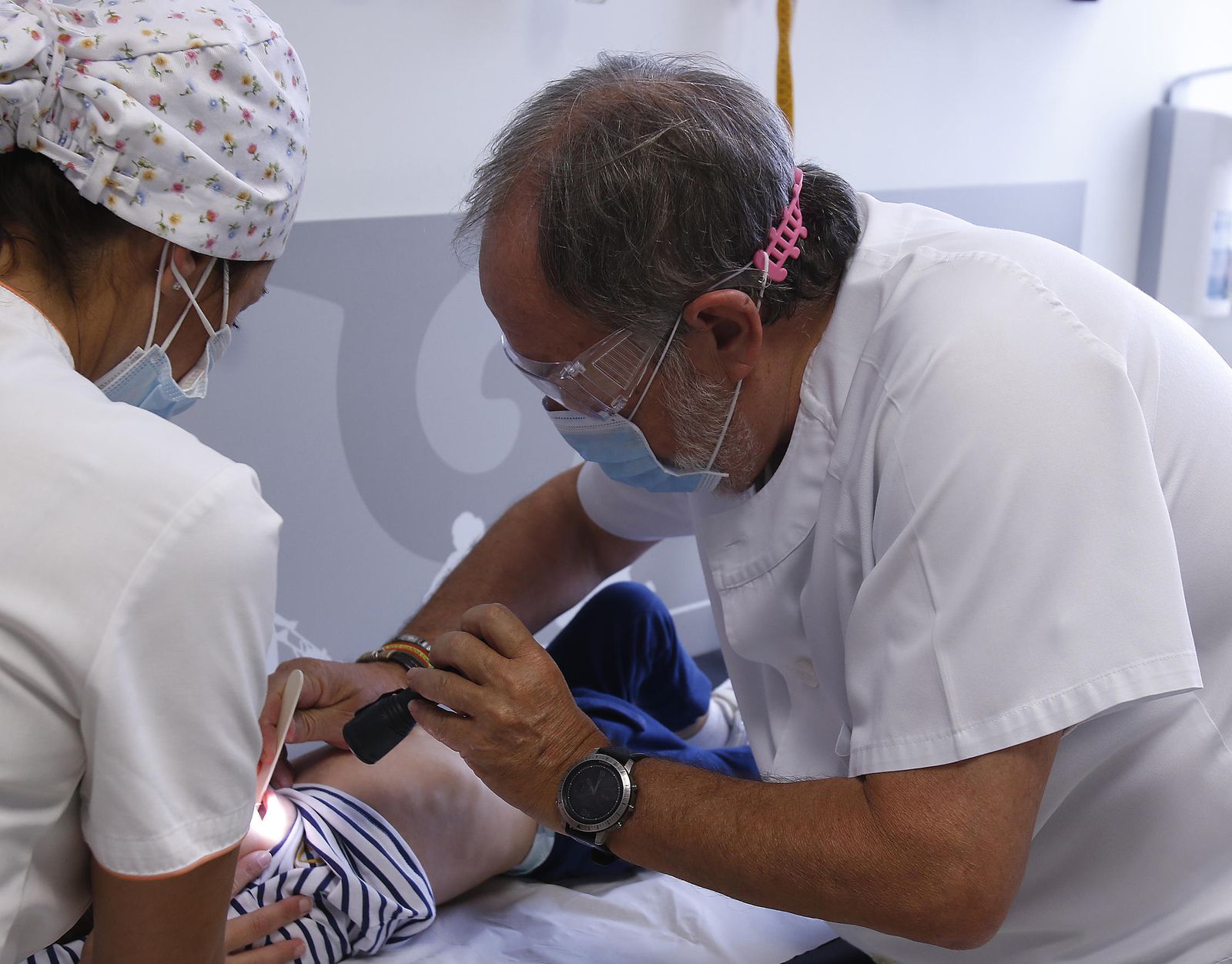 Imagen de archivo de un pediatra haciendo una exploración a un niño.
