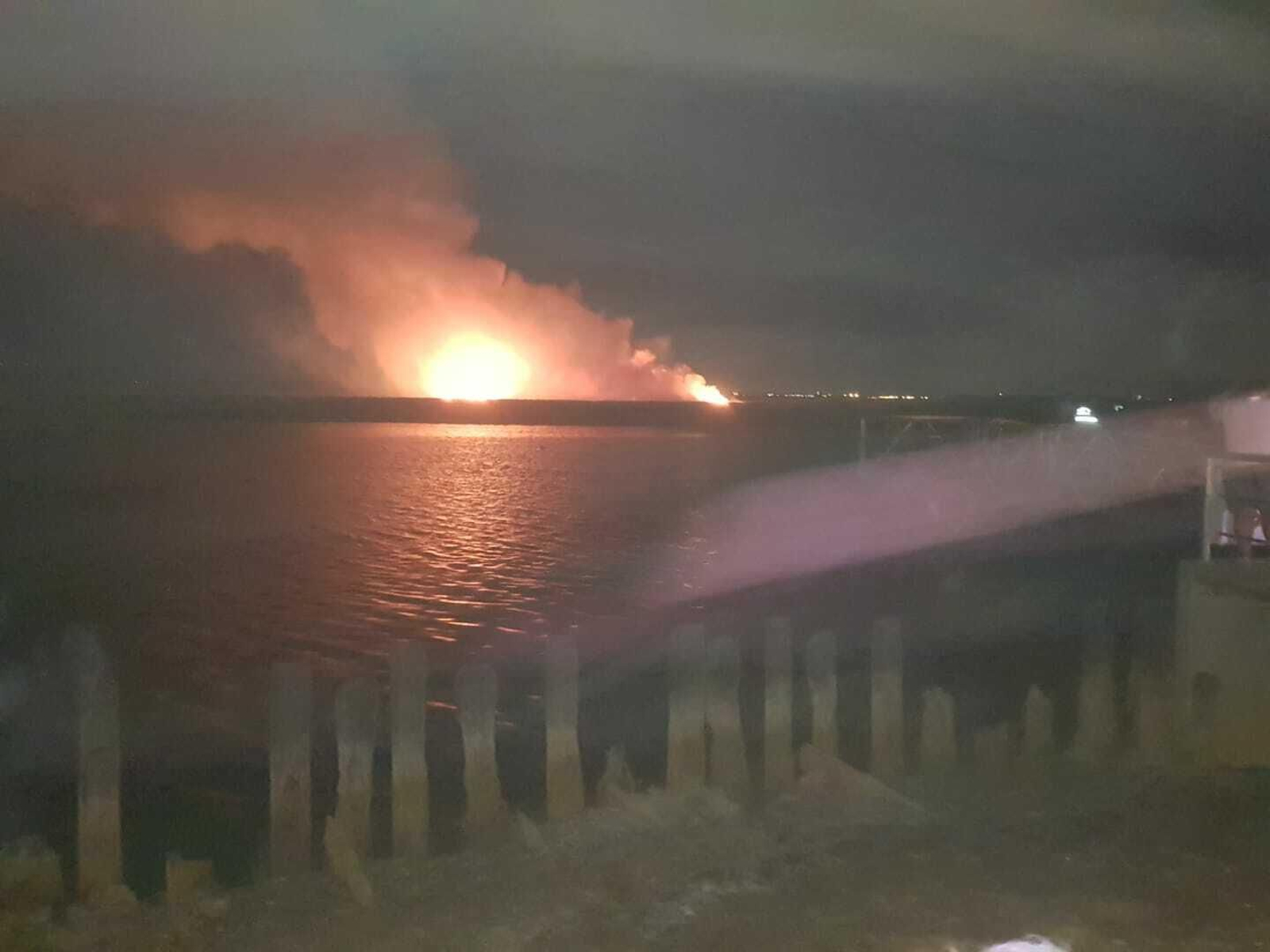 Incendio provocado por el accidente en la zona de marismas, visto desde el muelle de San Juan.
