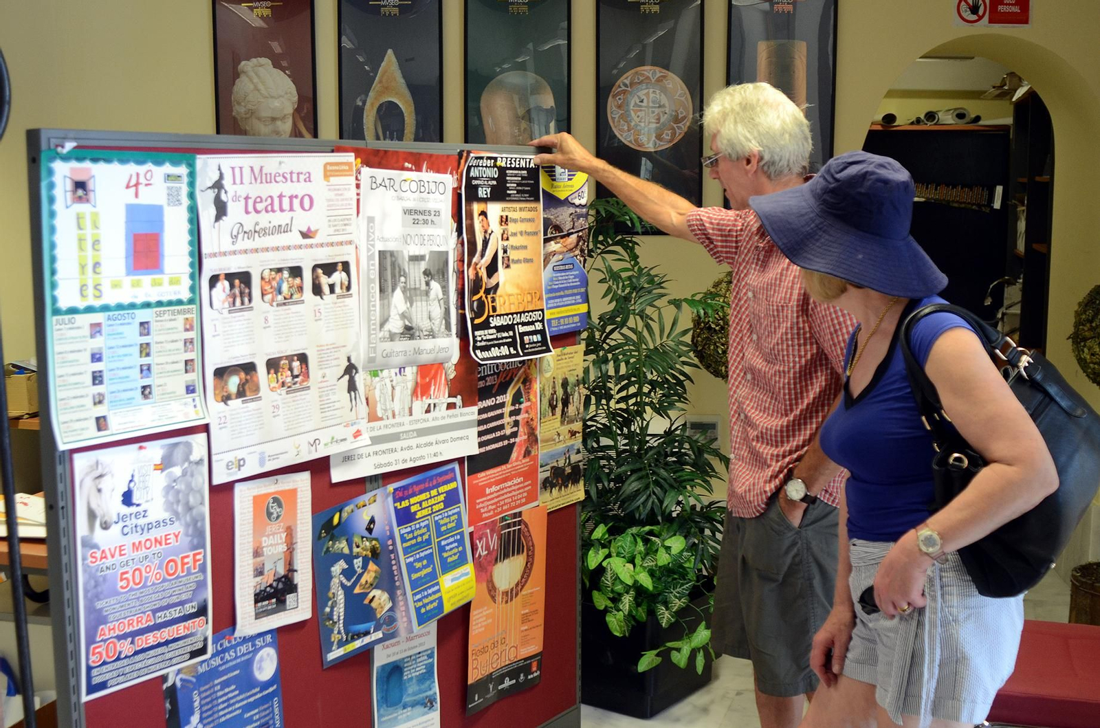 Dos turistas consultado un tablón de anuncios.