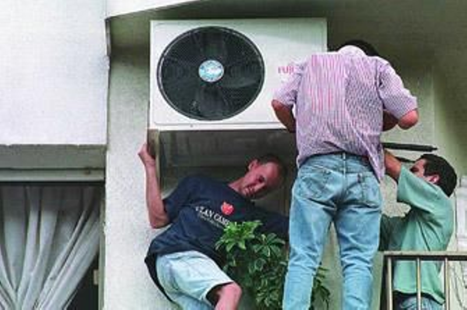 Trabajadores montando un aire acondicionado particular. /Pascual