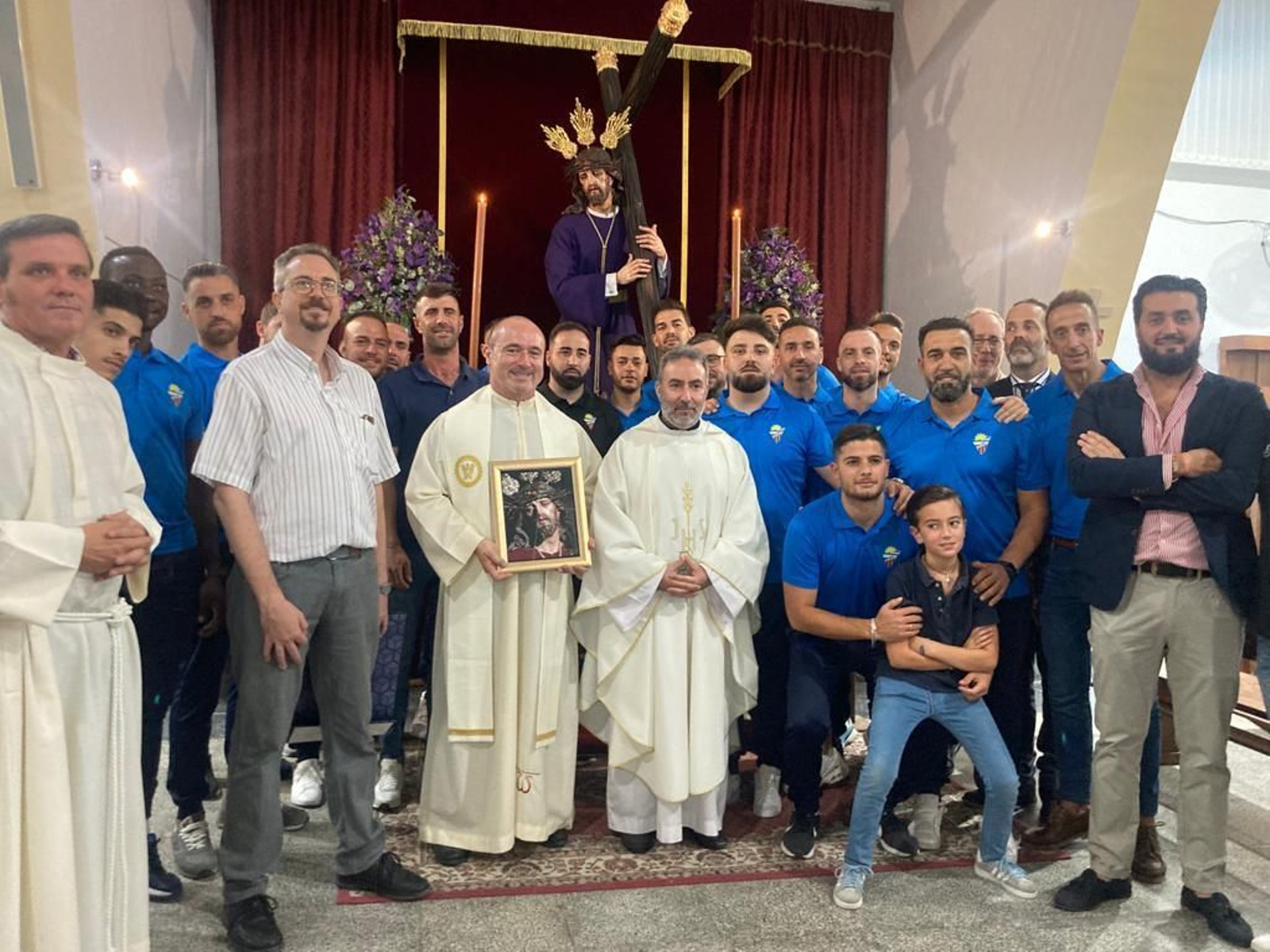 Foto de familia del equipo de fútbol, los Padres Paúles y el sacerdote párroco de San Rafael.