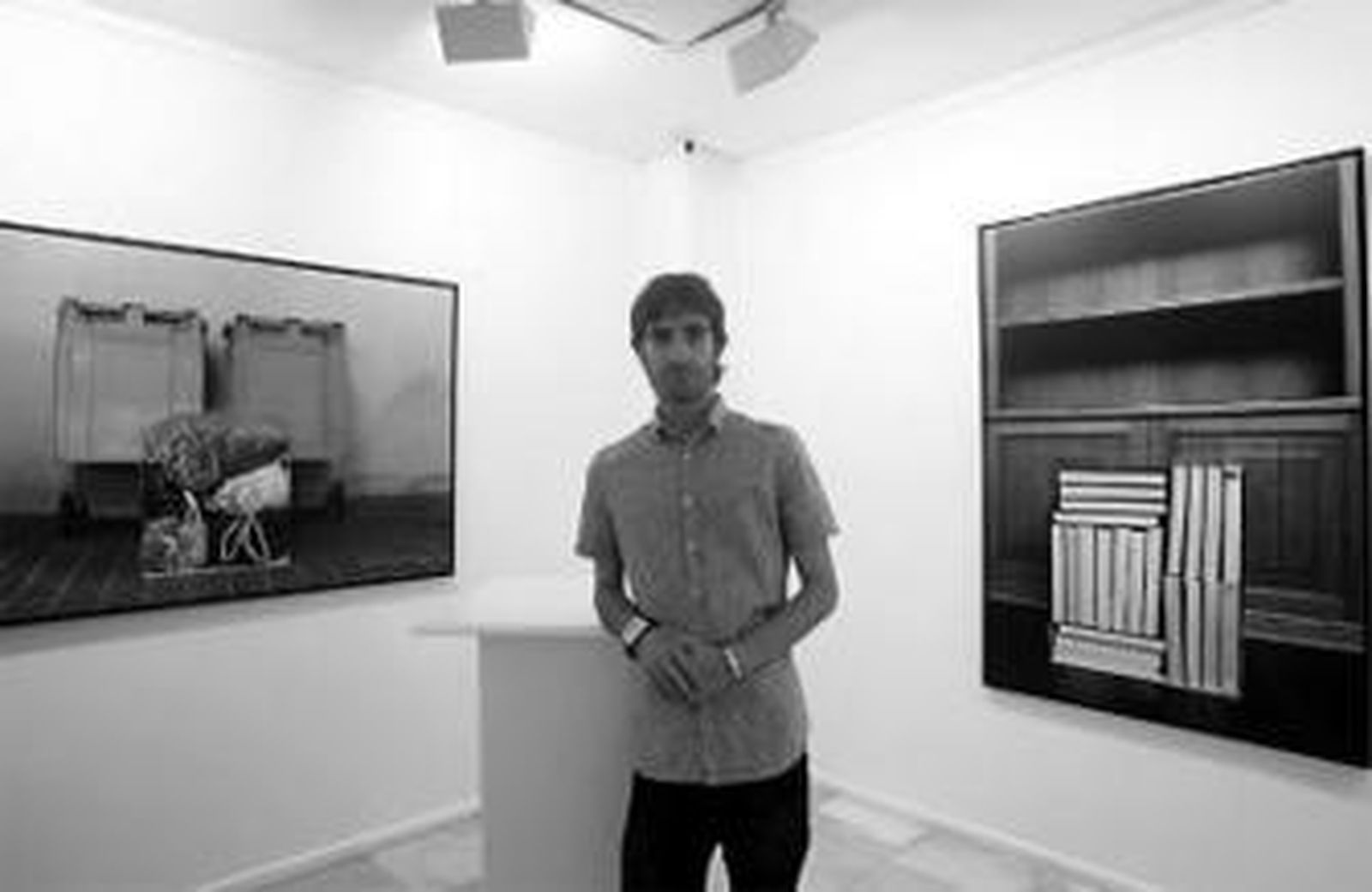 El artista Julio Galeote posa entre dos de sus fotografías