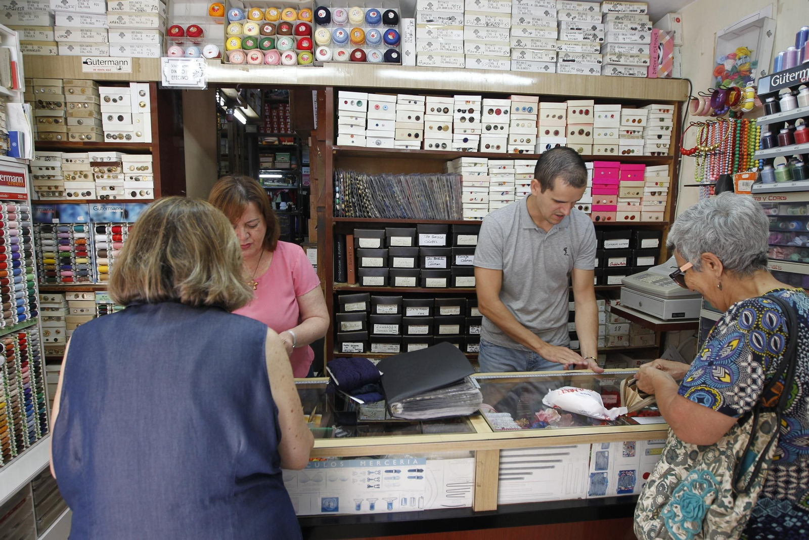 Francisca Mena y su hijo atienden a los clientes que acuden al comercio.